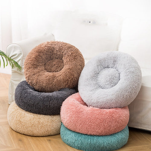 COJA Halo calming donut dog beds stacked on a wood floor, showing the round shape and raised plush rim